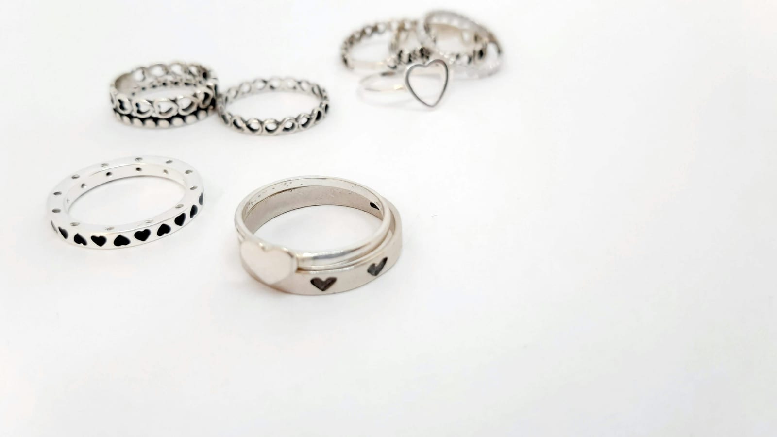 A stack of handmade sterling silver rings with hammered and smooth finishes